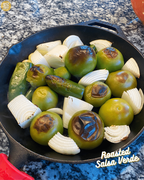 a cast iron pan full of roasted tomatillos, onions, and peppers.