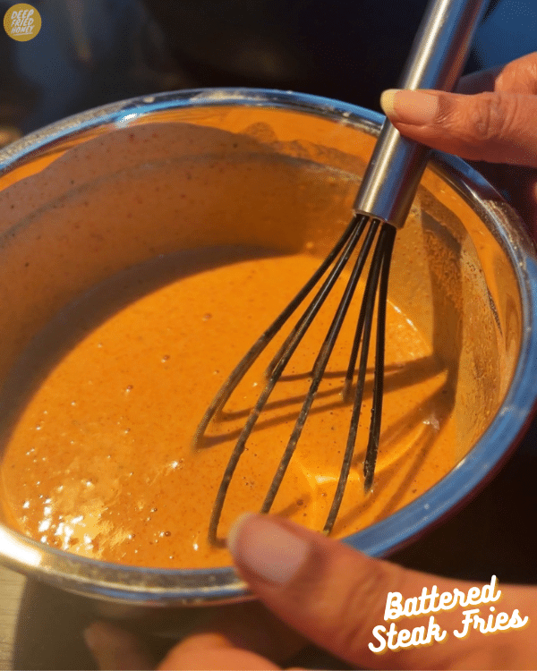 a bowl of batter, with a whisk still in it